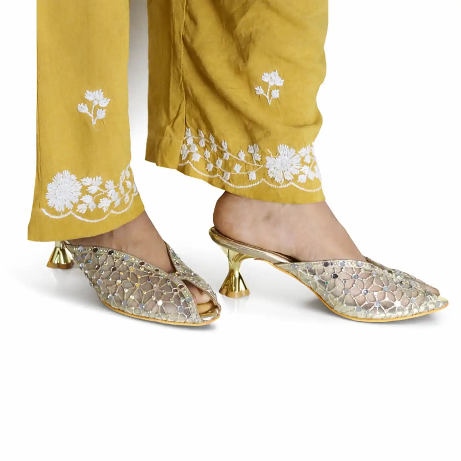 Gold kitten heel mules styled with embroidered pants