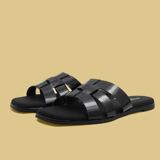 Black flat sandals with woven straps on a beige background
