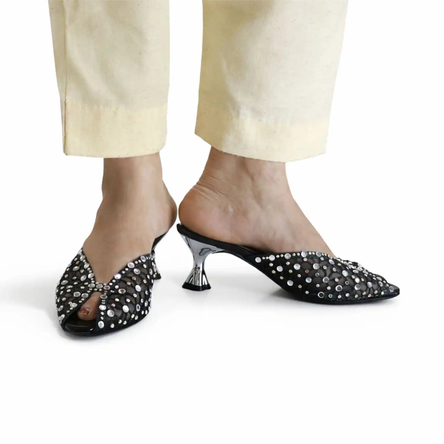 Black rhinestone kitten heel mules worn with beige pants