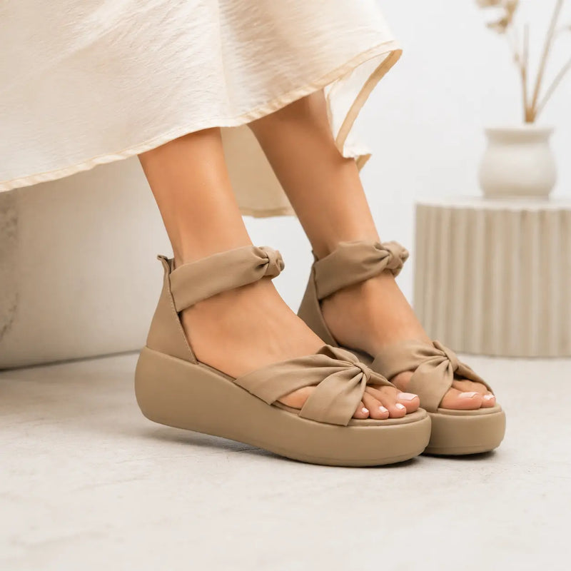 Lifestyle View of Women's Beige sandals worn with a light skirt on a neutral background