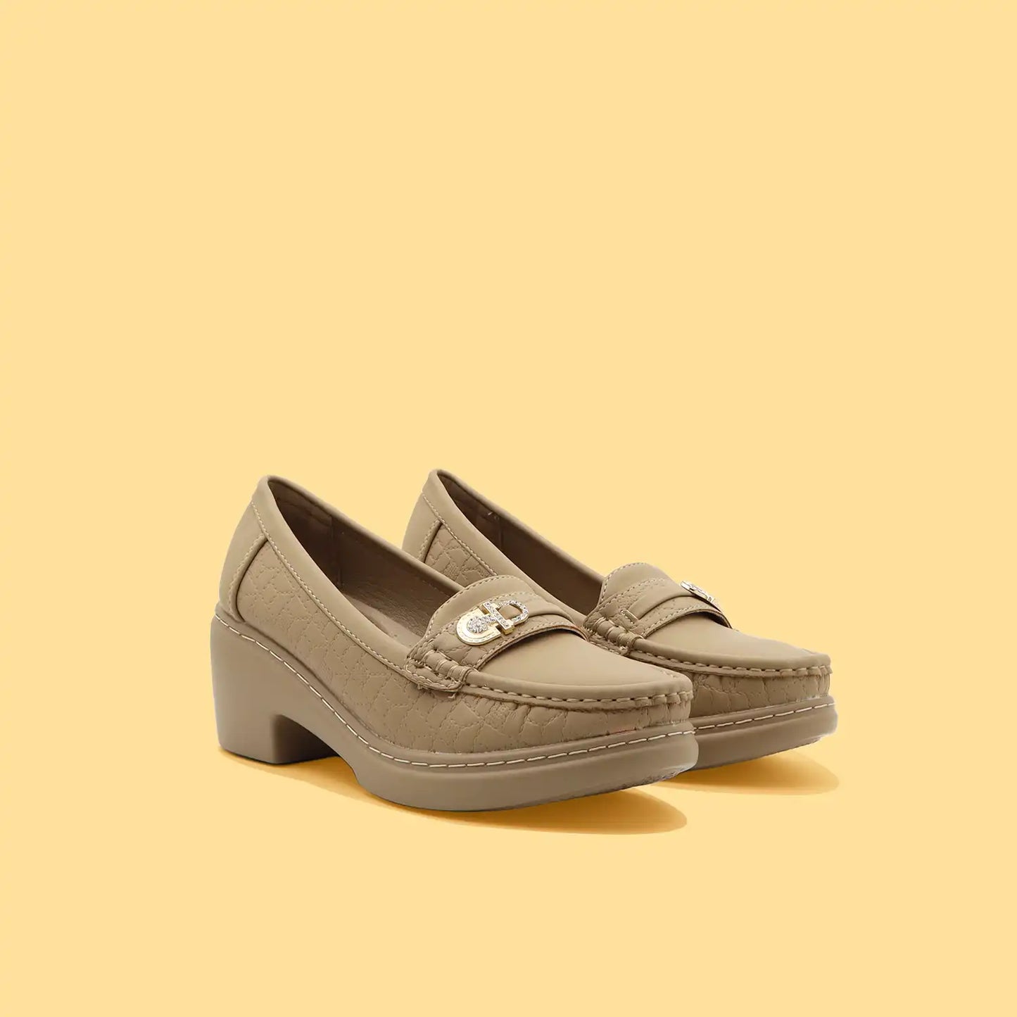 Pair of women's beige loafers with stitching on it