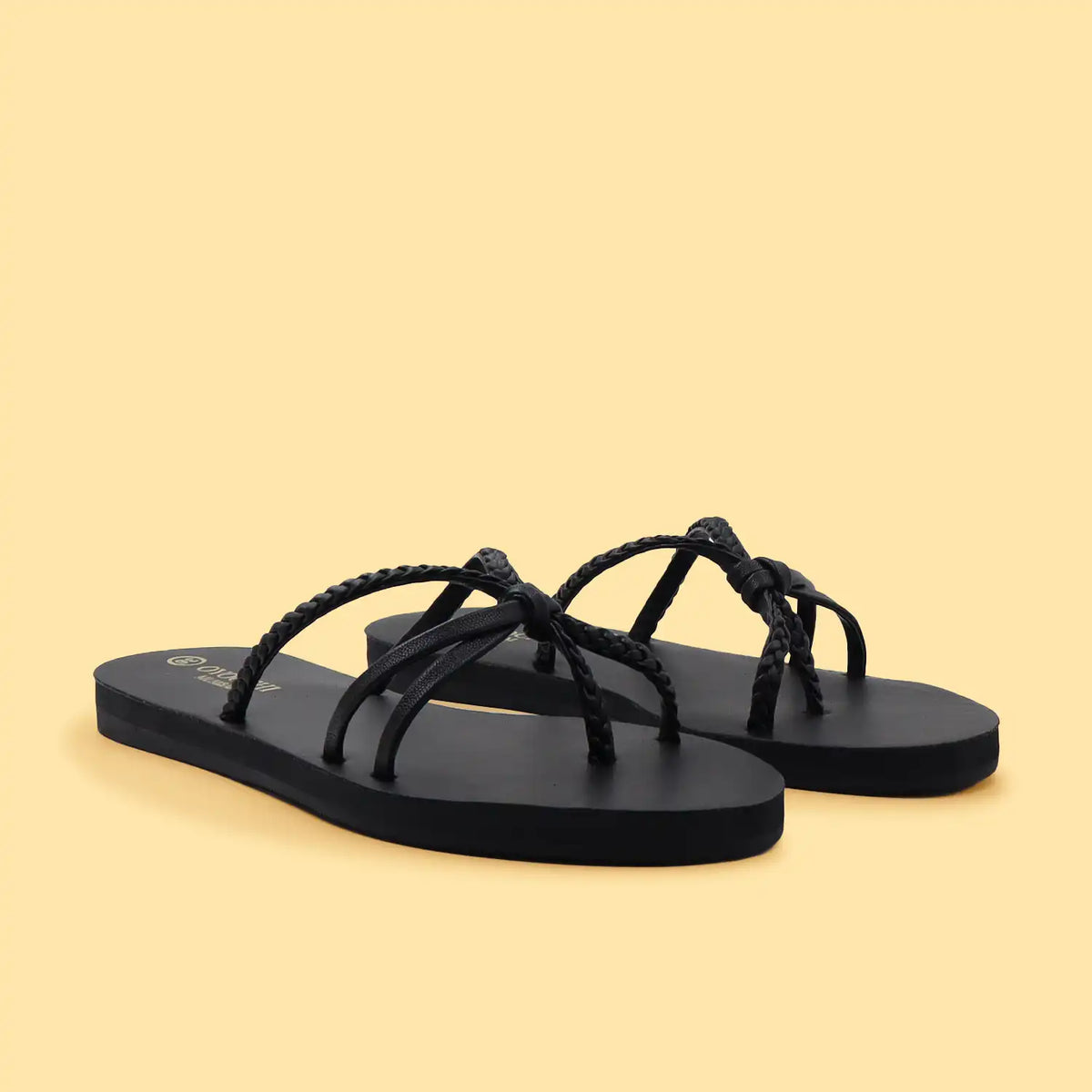 Black sandals with braided straps on a beige background for women and girls