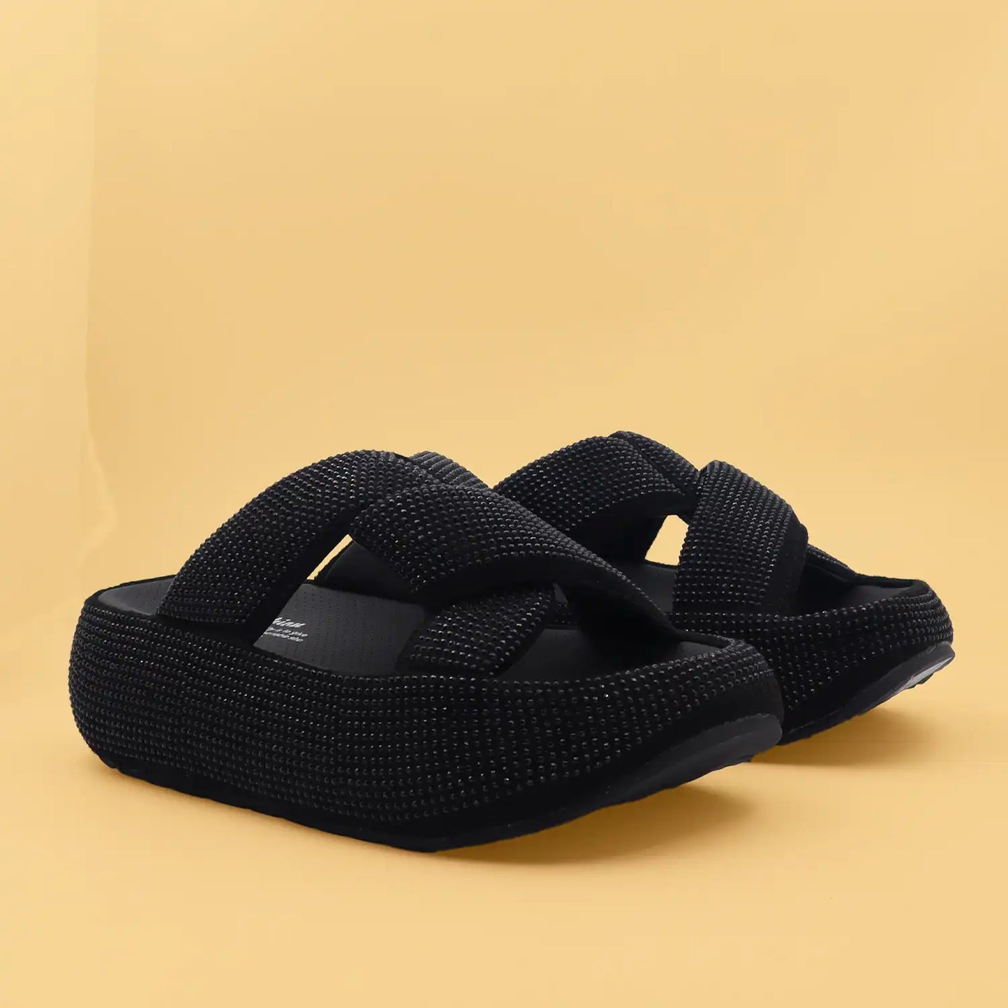 A pair of black platform slide sandals for women embellished with sparkling rhinestones