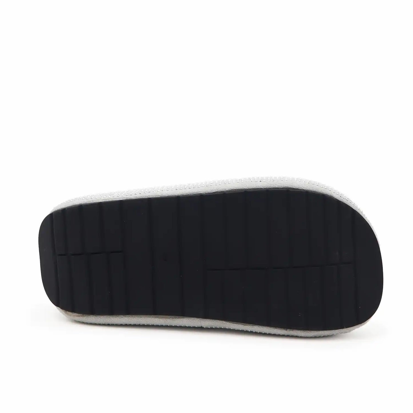 The black rubber outsole of a shoe, showing its textured tread pattern and white edge