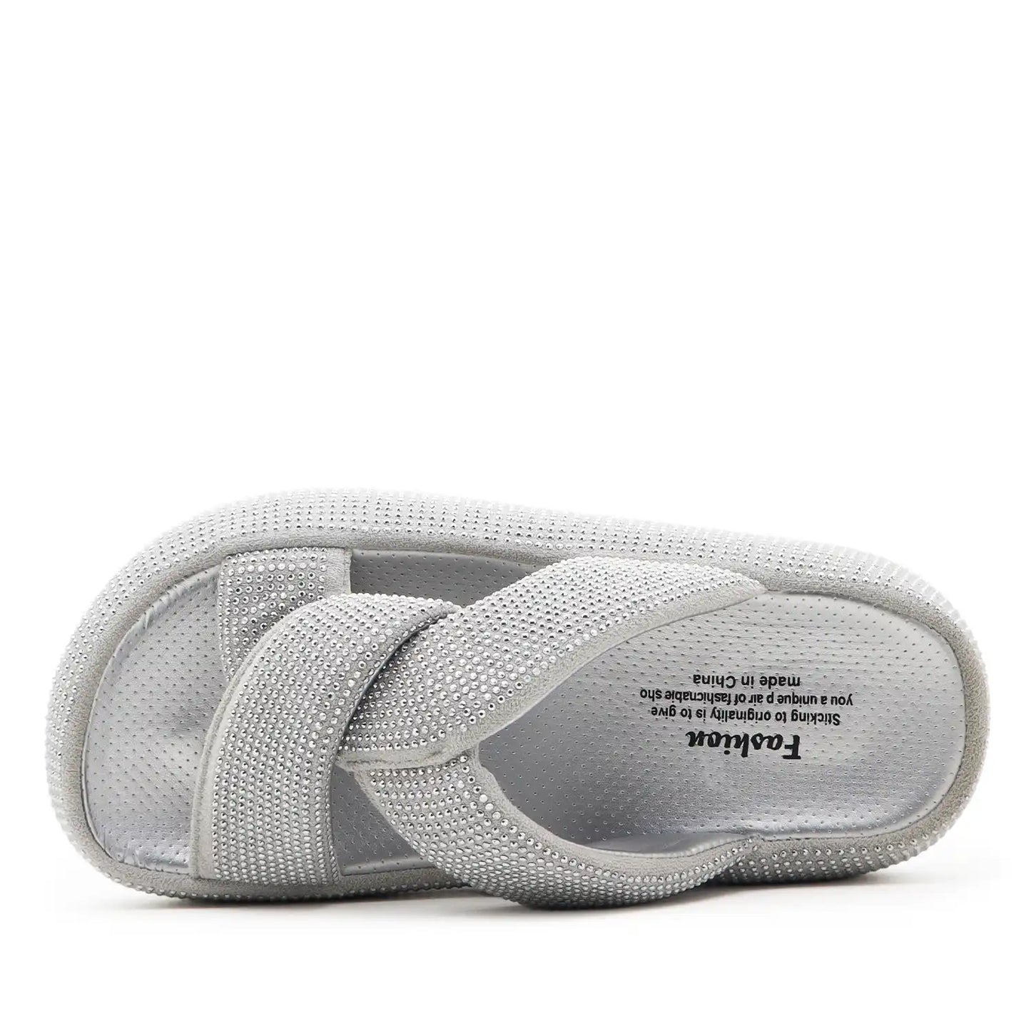 A light gray textured slip-on sandal with crisscrossing straps, shown from the side profile against a plain white background.