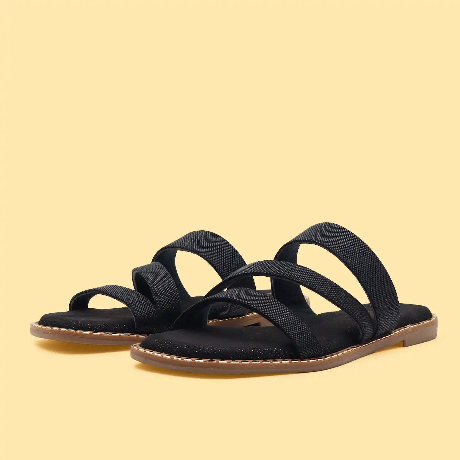 A pair of black strappy slide sandals with a textured fabric upper and a light brown sole